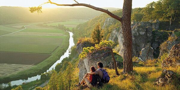 Paar sitz auf einem Berg und bestaunt die Landschaft 