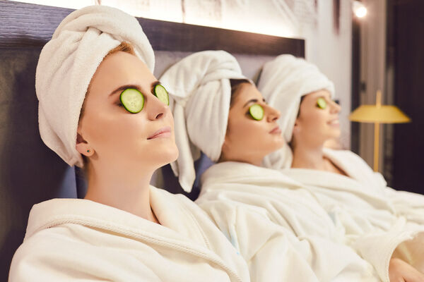 Drei Frauen in Bademänteln mit Gurkenscheiben auf den Augen beim Wellness in Bad Gögging