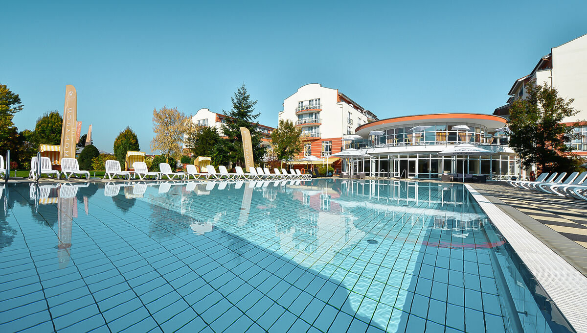 Großzügiger Außenpool bei Sonnenschein mit Relaxliegen am Beckenrand im Day Spa in Bayern