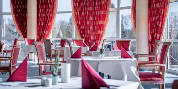 Gedeckte Tische mit roten Servietten im Restaurant in Bad Gögging mit großer Fensterfront
