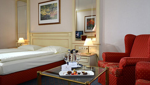 Zimmer mit Bett und Sessel im The Monarch Hotel